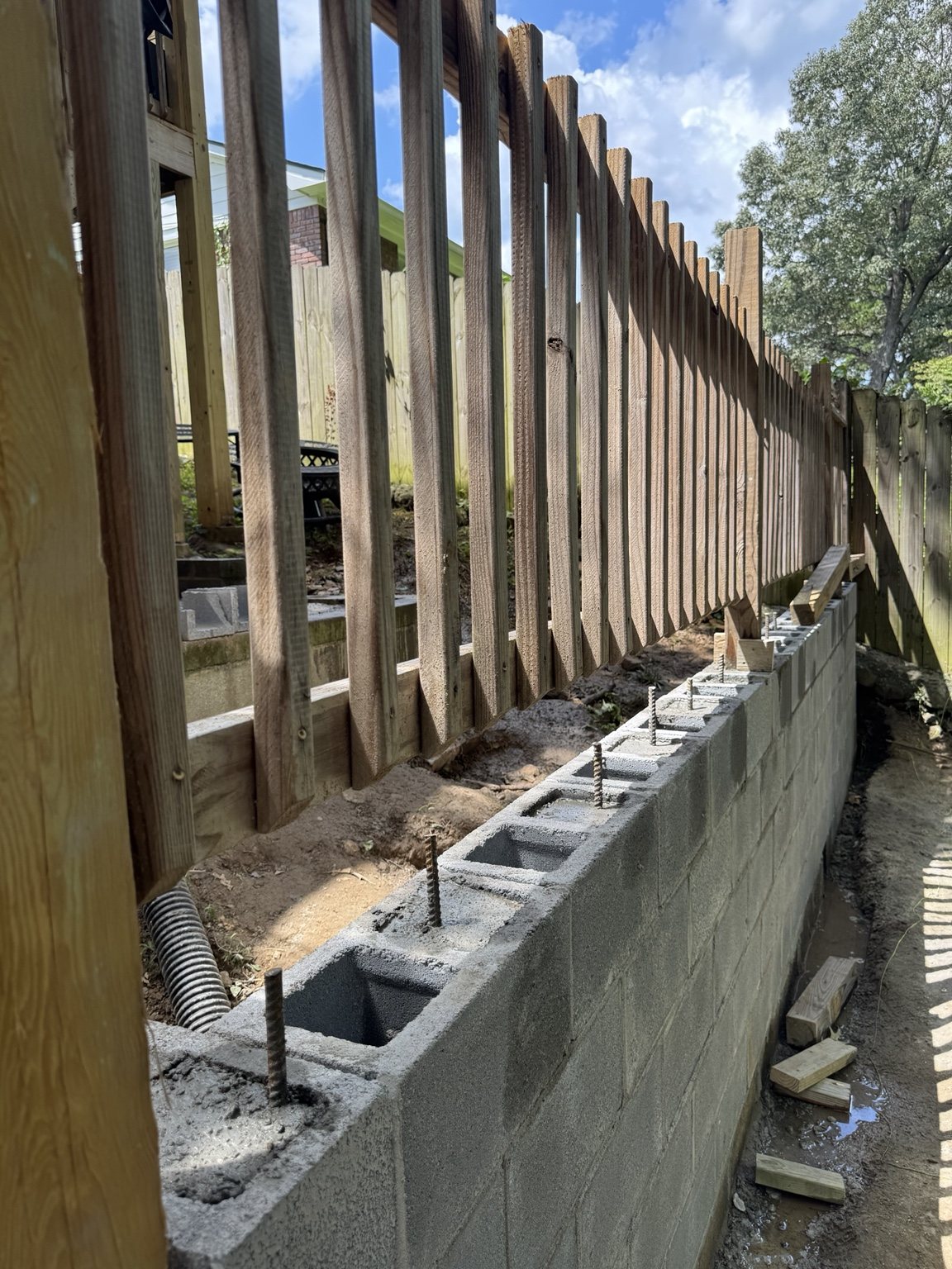 CMU retaining wall construction with reinforced block